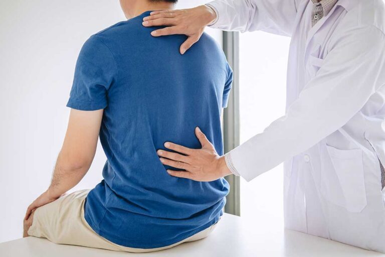 Pregnant person doing a gentle hands-and-knees back stretch on a living room mat.